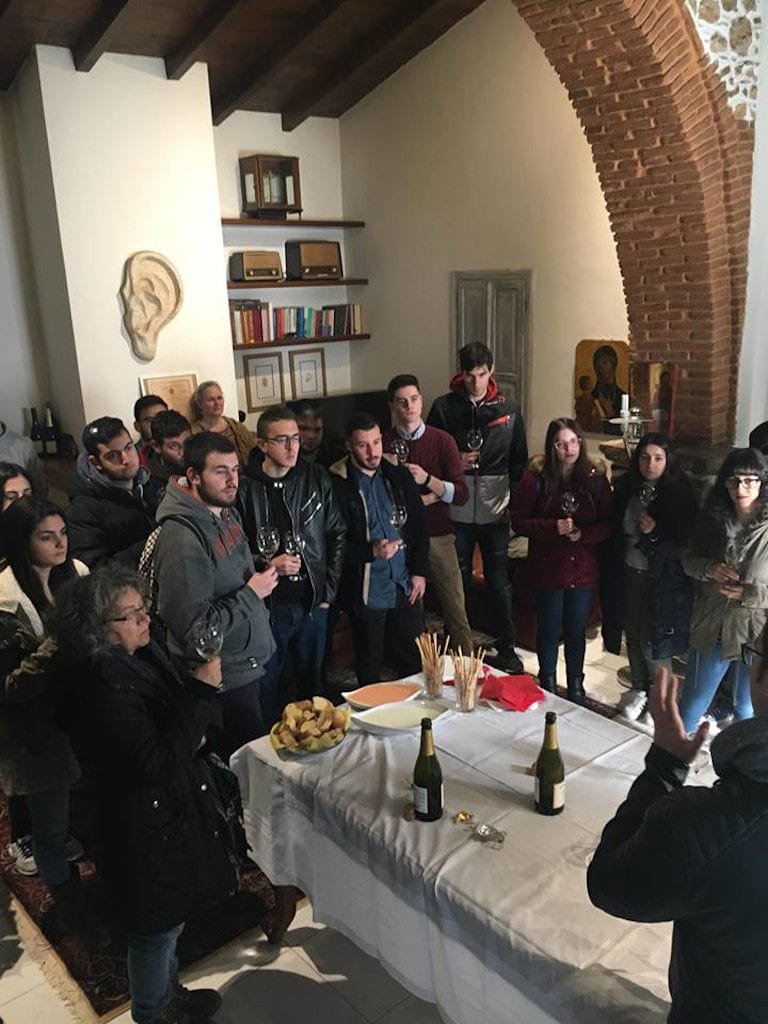 tourists tasting wines and listening to a man giving a tour at Nikolou Winery